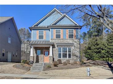 Two-story house with blue siding, brick accents, and a peach-colored door at 2329 Village Grove Dr, Suwanee, GA 30024