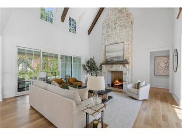 Bright and airy living room with soaring ceilings, stone fireplace, and sliding glass doors to the backyard at 464 Pine Tree Ne Dr, Atlanta, GA 30305