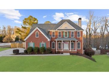 Brick two-story house with a large front yard and attached garage at 4450 Fairfax Dr, Cumming, GA 30028