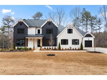 Two-story farmhouse-style home with white and black exterior, and landscaping at 208 Pindos Sw Pl, Powder Springs, GA 30127