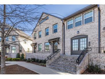 Brick front elevation of charming townhome with welcoming porch and stairs at 2487 Figaro Dr, Atlanta, GA 30339