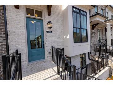 Charming brick townhouse featuring a teal front door and black wrought iron railings on the entry stairs at 530 Fisher Dr # 45, Alpharetta, GA 30009