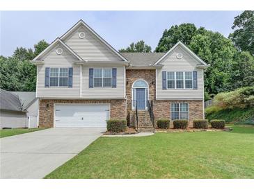 Two-story house with stone accents, a two-car garage, and a well-manicured lawn at 770 Dunagan Forest Dr, Lawrenceville, GA 30045