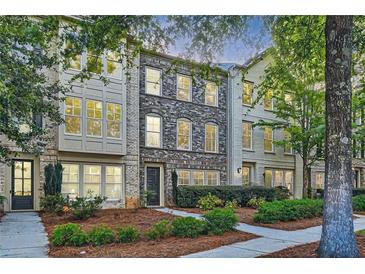 Three-story townhouses with brick exteriors and landscaped yards at 9972 Ashton Old Rd, Douglasville, GA 30135