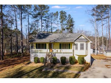 Ranch style home with front porch and deck, nestled in a wooded setting at 1094 Plantation Ct, Villa Rica, GA 30180