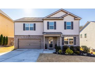 Two-story house with a brick facade, attached garage, and landscaped lawn at 145 Lost Cove Sw Dr, Atlanta, GA 30331