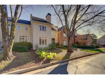 Beige townhome with manicured landscaping and mature trees at , Atlanta, GA 30327