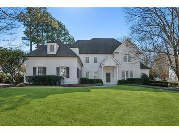 Stunning two-story white brick home with a manicured lawn at 115 N Devereux Nw Ct, Atlanta, GA 30327