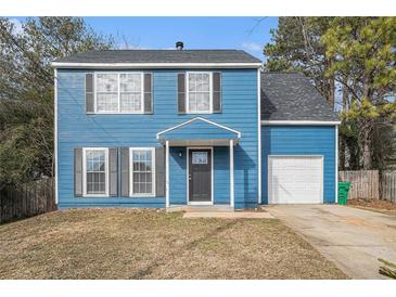 Charming two-story blue house with a gray door and attached garage at 3530 Kingsbrooke Ct, Decatur, GA 30034