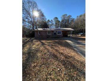 Brick ranch house with a large yard and driveway at 116 E Wade St, Oxford, GA 30054