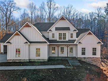 Two-story farmhouse with white siding, stone accents, and a covered porch at 221 Heritage Town Pkwy, Canton, GA 30115