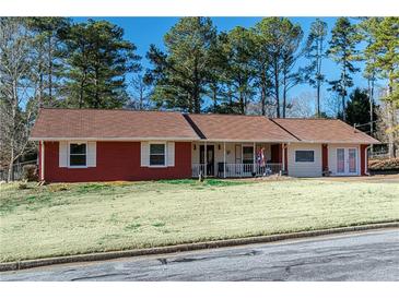 Ranch style brick home with a spacious front yard and mature trees at 1830 Brandy Se Ln, Conyers, GA 30013