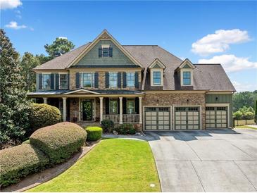 Two-story house with stone accents, 3-car garage, and manicured lawn at 5585 Lavender Farms Rd, Powder Springs, GA 30127