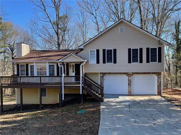 Two-story house with a two car garage, deck and landscaped yard at 1921 Clinton Pl, Lawrenceville, GA 30043