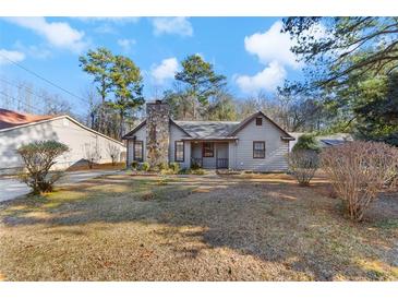 House exterior featuring a stone fireplace and well-maintained lawn at 285 Independence Dr, Jonesboro, GA 30238