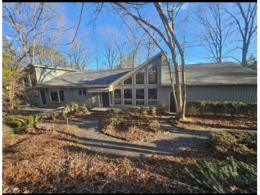 Gray house with large windows, deck, and stone walkway, nestled in a wooded area at 190 Valley Cv, Atlanta, GA 30350