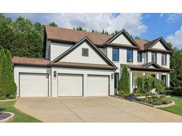 Charming two-story home with a three-car garage, landscaped front yard, and inviting curb appeal at 334 Spotted Ridge Cir, Woodstock, GA 30188