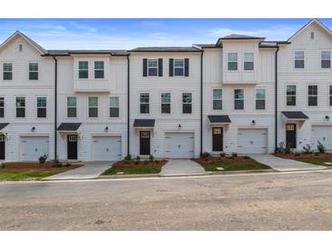 Exterior view of townhouses with white siding, black shutters, and attached garages at 3172 Washburn Sw St, Atlanta, GA 30354