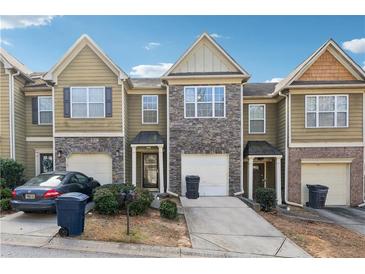 Townhouse exterior featuring stone accents and a two-car garage at 509 Tufton Se Trl, Atlanta, GA 30354