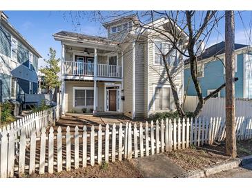 Tan two-story house with white picket fence and balcony at 320 Harden Se St, Atlanta, GA 30312