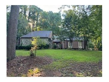 Brick ranch home with mature trees and a large lawn at 8374 Carlton Rd, Riverdale, GA 30296