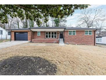 Charming brick home features a garage, well-maintained lawn, and inviting front entrance at 649 Ozburn Nw Rd, Atlanta, GA 30318