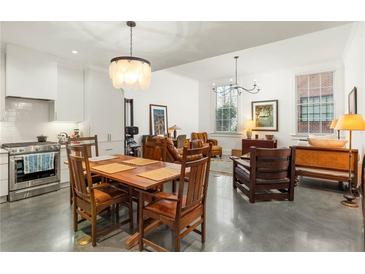 Modern white kitchen with stainless steel appliances and an eat-in dining area at 10625 Serenbe Ln # 103, Chattahoochee Hills, GA 30268