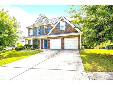 Brick two-story house with a two-car garage and landscaped lawn at 3745 Park Hill Cir, Loganville, GA 30052