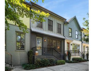 Modern townhouses with gray, green, and yellow siding, featuring black metal railings and landscaping at 1187 Rambler Cross, Atlanta, GA 30312