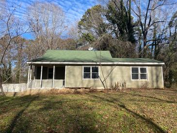 Ranch style home with green roof and mature trees at 214 Pinewood Ln, Stockbridge, GA 30281