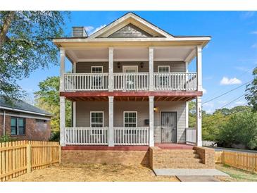 Two-story house with front porch, fenced yard, and brick accents at 1410 Metropolitan Sw Pkwy, Atlanta, GA 30310