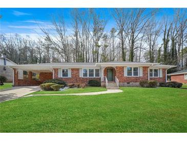 Brick ranch home with landscaped lawn and attached carport at 719 Lynn Valley Sw Rd, Atlanta, GA 30311