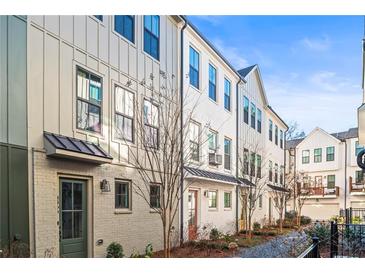 Exterior view of charming townhomes with light-colored brick and siding at 4462 Dandelion Ln, Atlanta, GA 30342