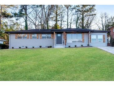 Newly renovated ranch home with gray brick, wood accents, and a landscaped lawn at 2933 Edna Ln, Decatur, GA 30032