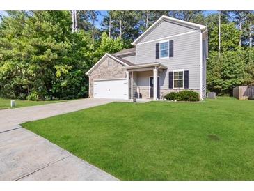 Two-story house with gray siding, stone accents, and a spacious lawn at 7977 Rudder Cir, Fairburn, GA 30213