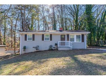 Charming ranch home with gray brick exterior and a well-manicured lawn at 3578 Adkins Nw Rd, Atlanta, GA 30331