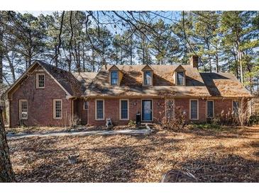 Brick house with dormers, mature trees, and a large yard at 5275 Johnson Spur, Loganville, GA 30052