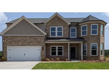 Two-story brick home with a three-car garage and landscaped lawn at 67 Longhorn Way, Auburn, GA 30011