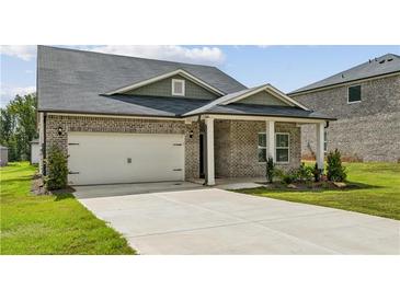 Brick house with a two-car garage and a covered porch at 7788 Richmond Trl, Fairburn, GA 30213
