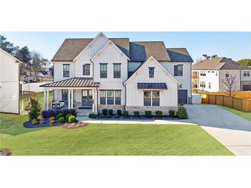 Beautiful two-story home with a covered front porch and professionally landscaped yard and a long driveway at 4973 Concert Ln, Marietta, GA 30066