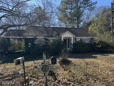 Charming one-story house with overgrown landscaping and mature trees at 2504 Dickson Cir, Lawrenceville, GA 30044