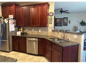 Spacious kitchen with dark wood cabinets, granite countertops, and stainless steel appliances at 709 Chapman St, Jonesboro, GA 30238
