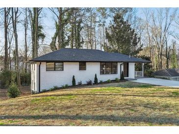 Charming ranch home with white brick exterior, updated landscaping, and a spacious driveway at 1120 Starline Se Dr, Smyrna, GA 30080