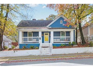 Charming blue house with white trim, front porch, and landscaped yard at 516 Arthur Sw St, Atlanta, GA 30310