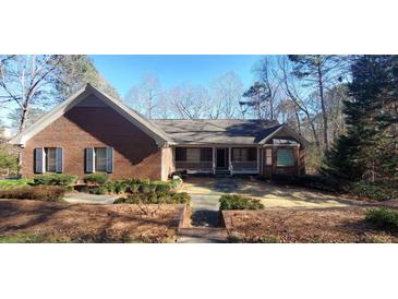 Brick house with gray roof, shutters, and a porch at 1030 Lake Haynes Ne Dr, Conyers, GA 30012