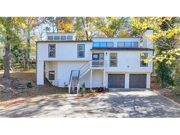 Stunning two-story home with gray and white exterior, attached garage, and landscaping at 2490 Woodfern Ct, Marietta, GA 30062