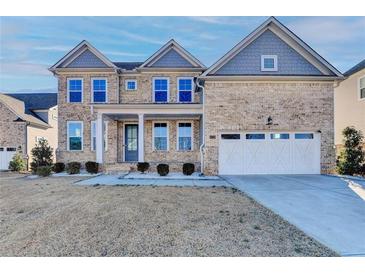 Two-story brick home with a large front porch and three-car garage at 4725 Shipley Ave, Cumming, GA 30028