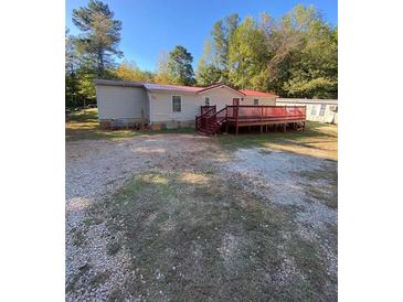 Single-wide mobile home with red deck and large yard at 615 Woodruff Rd, Carrollton, GA 30116