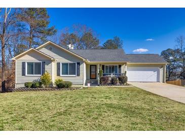 Ranch style home with landscaped lawn, attached garage, and neutral siding at 775 Holcombe Woods Ct, Auburn, GA 30011