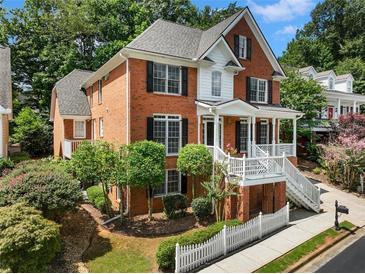 Brick two-story house with a front porch and a white picket fence at 2750 Olde Towne Pkwy, Duluth, GA 30097